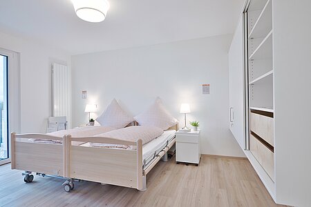 Blick ins Schlafzimmer des DeinHaus 4.0 Wohnkompetenzzentrums Freilassing mit unterfahrbaren Schränken