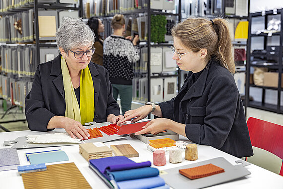 Prof. Anette Ponholzer bei der Materialauswahl mit der Studierenden Luzie Kurz