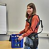 Das Bild zeigt Professorin Hanna Brandt mit einem Exoskelett.