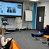 Das Bild zeigt Studierende, die in einem Raum auf Sitzkissen sitzen und am Trainingsprogramm Intercultural Leadership teilnehmen.