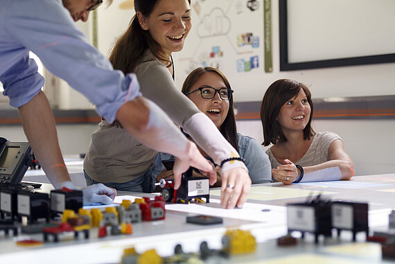 Ein Student und drei Studentinnen bei der Gruppenarbeit im Labor Industrie 4.0