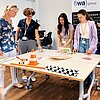 Das Bild zeigt vier Schülerinnen, die sich bei einem Workshop an der TH Rosenheim mit einer technischen Aufgabe befassen.