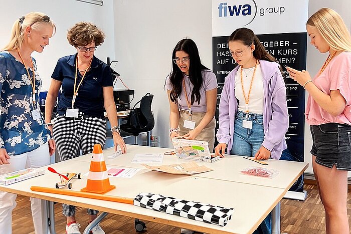 Das Bild zeigt vier Schülerinnen, die sich bei einem Workshop an der TH Rosenheim mit einer technischen Aufgabe befassen.