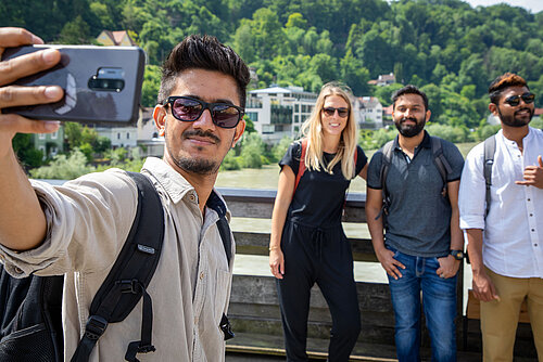 Studierende machen ein Selfie auf der Salzach-Brücke in Burghausen.