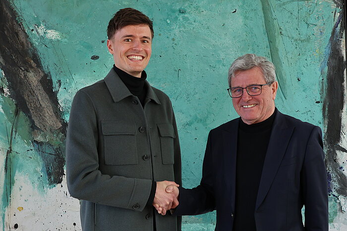 Das Bild zeigt Professor Lukas Flohr mit Hochschulpräsident Professor Heinrich Köster