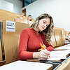 Studentin im Hörsaal beim Schreiben einer Prüfung