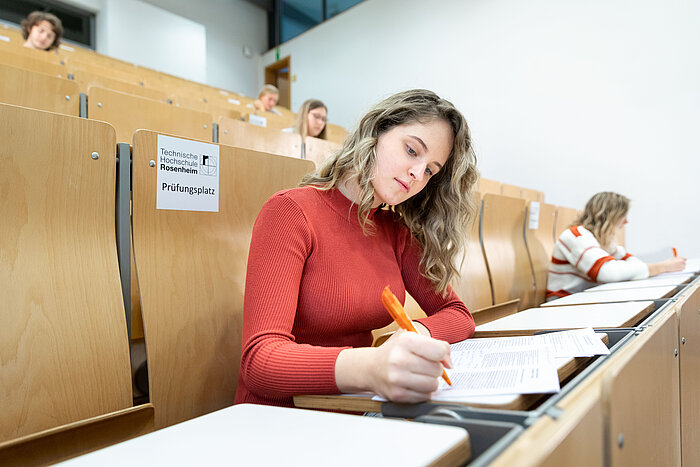 Studentin im Hörsaal beim Schreiben einer Prüfung