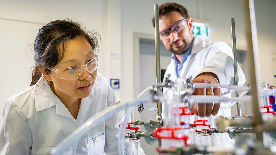A student and professor in a lab in Burghausen.