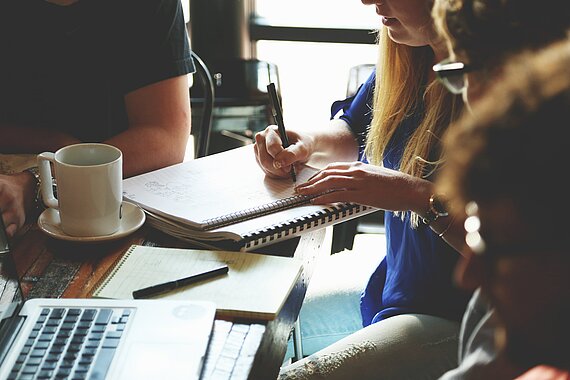 [Translate to English:] Gruppe junger Menschen beim Schreiben von wissenschaftlichen Arbeiten