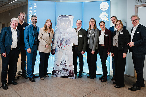 Das Bild zeigt eine Gruppe von Personen neben einem Astronauten-Aufsteller.