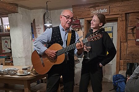 Ein Musiker singt, eine Frau steht daneben und hört zu.