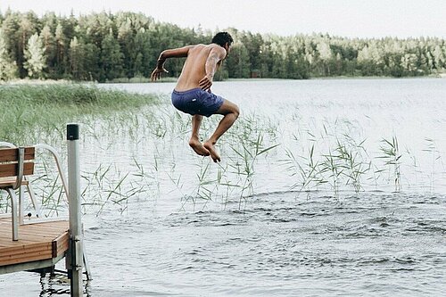 Ein Student springt in einen See.