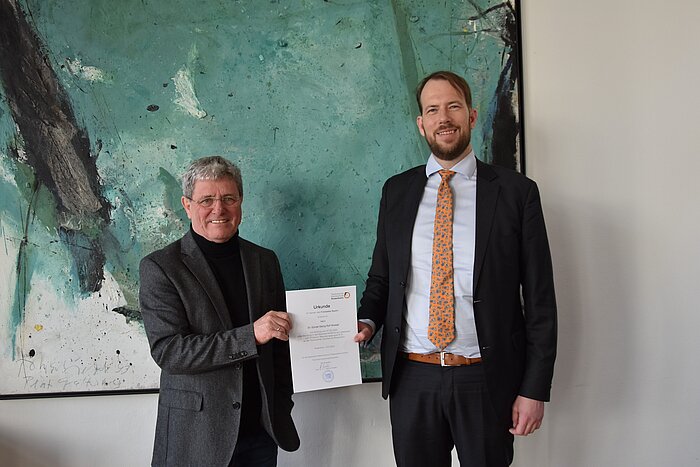 Das Foto zeigt die Vereidigung von Dr. Günter Modzel, rechts im Bild, durch Hochschulpräsident Prof. Heinrich Köster, links im Bild.