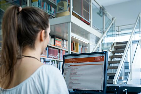 Bibliotheksnutzerin vor einem Recherche-PC 