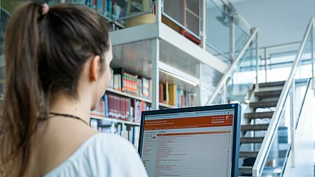 Bibliotheksnutzerin vor einem Recherche-PC 