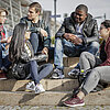 Das Bild zeigt Studierende, die auf einer Treppe am Campus Rosenheim sitzen.