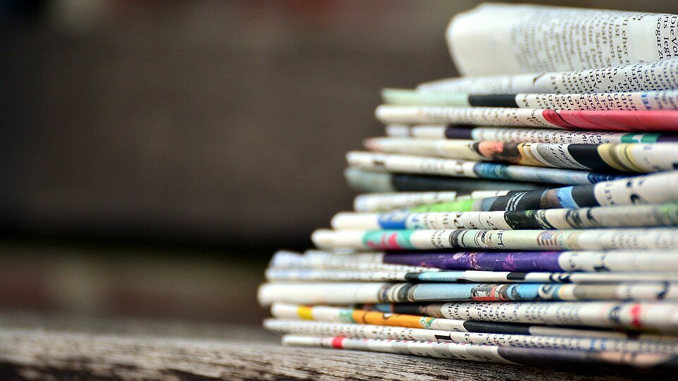 Ein Stapel zusammengelegter Zeitungen auf einem Tisch 