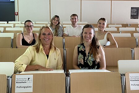 Die Betreuer Prof. Dr. Brigitte Kölzer und Michaela Polz sitzen zusammen mit den Studentischen Team im Hörsaal für ein Gruppenbild