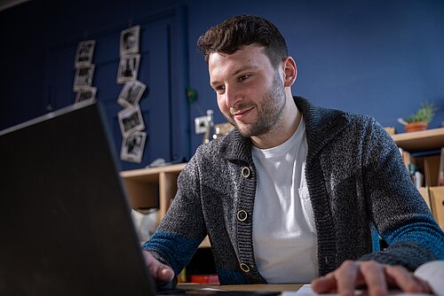 Student zu Hause am Laptop am Schreibtisch