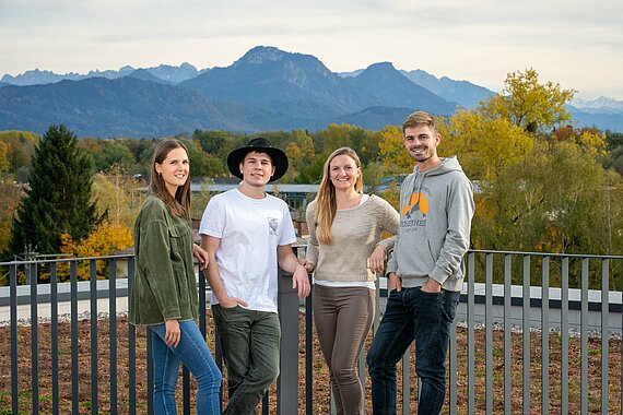 Group of students on the rooftop with mountains in the background