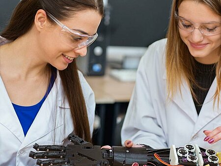 Two students looking at a prosthetic hand.