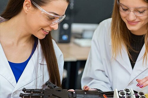 Two students looking at a prosthetic hand.