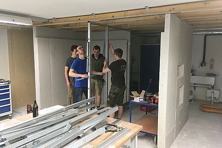 Ein Studententeam erstellt im Praktikum seine Trockenbauwand mit Lichtvouten, zurückspringendem Sockel und integrierten Nischen 