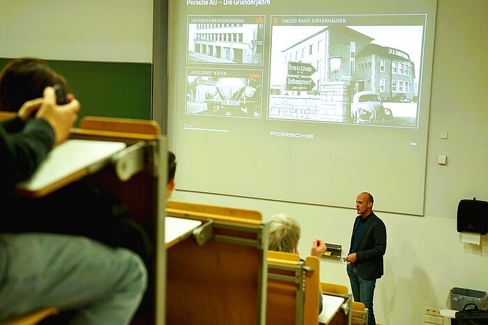 Das Bild zeigt Christoph Bauernfeind von der Porsche AG bei seinem Vortrag an der TH Rosenheim.