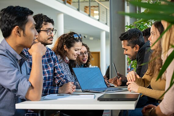 Group of international students at a table with laptop