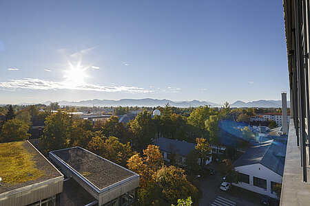 Sonniger Ausblick auf das Bergpanorama aus einem Hochschulgebäuder der TH Rosenheim am Campus Rosenheim.