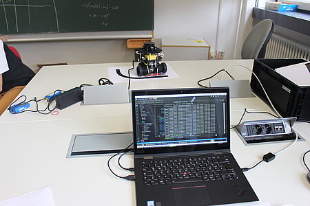 Laptop mit Anzeige zahlreicher gewonnener Datensätze, im Hintergrund der eingesetzte TurtleBot (Labor für Echtzeitsysteme)