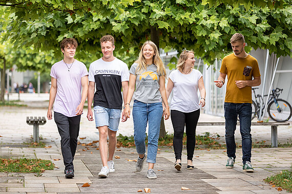 Eine Gruppe Studierender der TH Rosenheim nebeneinander laufend am Campus 