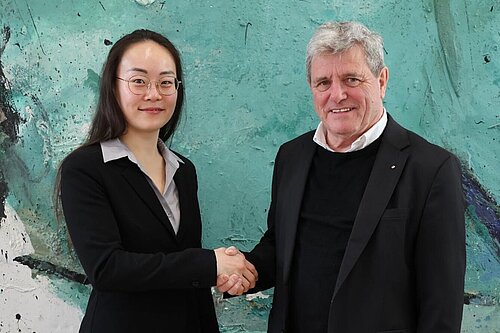 Das Bild zeigt Professorin Elisabeth Shi mit Hochschulpräsident Professor Heinrich Köster