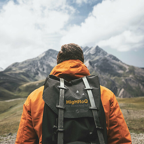 Ein Mann mit vollgepacktem Rucksack begibt sich auf den Weg zu einer Bergwanderung.