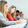 Studentinnen und Studenten im Hörsaal in einer Reihe