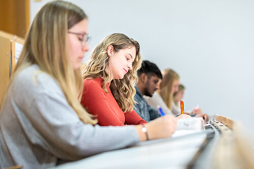 Studentinnen und Studenten im Hörsaal in einer Reihe