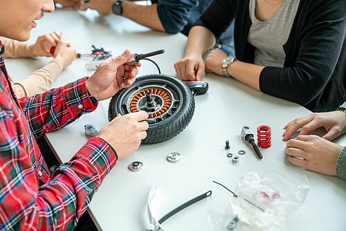 Students working on a scooter.