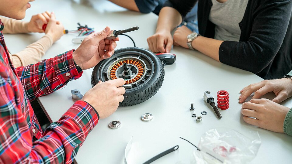 Students working on a scooter.