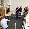 Das Bild zeigt Studenten, deren Modellbrücke auf einem Prüfstand einem Belastungstest unterzogen wird.