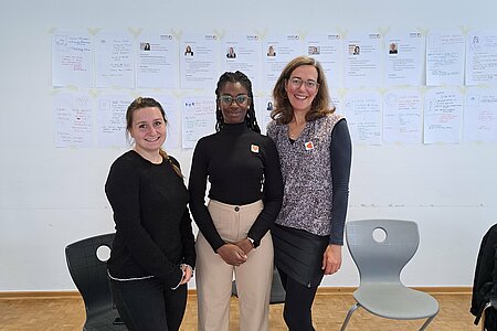 3 Frauen stehen im Workshop Raum.