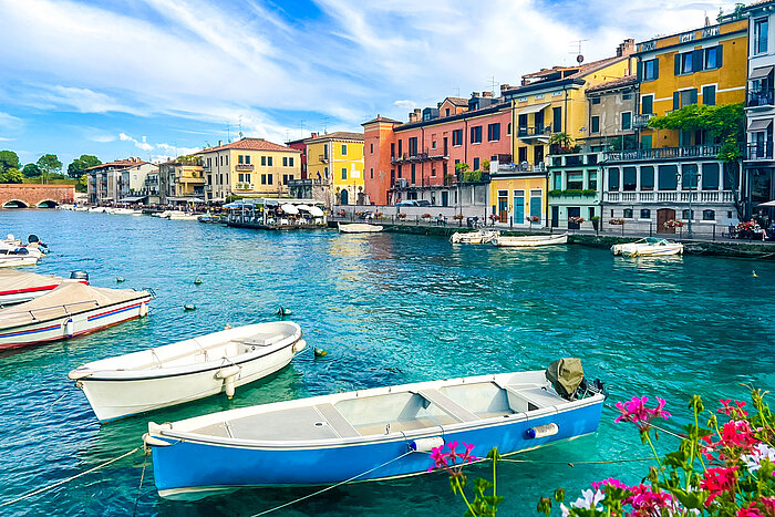 Blick auf den Canale di Mezzo mit kleinen Booten und bunten Häusern in Peschiera del Garda
