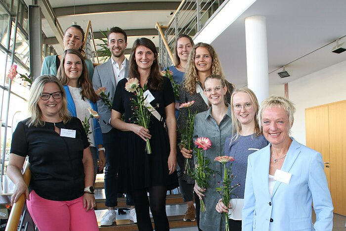 Das Bild zeigt eine Gruppe von Personen auf einer Treppe stehend.