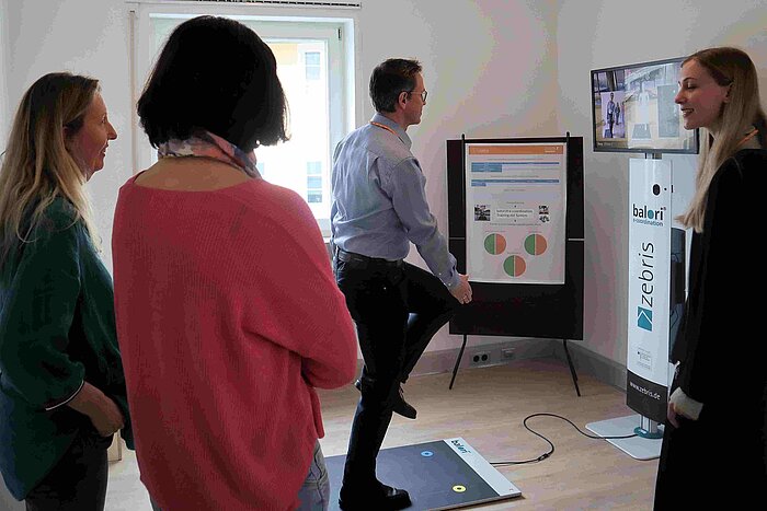 Das Bild zeigt eine Person, die im Wohnkompetenzzentrum Amerang ein Gerät aus dem Bereich eHealth ausprobiert.
