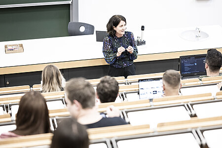 Eine Dozentin, die Studierende im Hörsaal unterrichtet