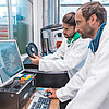 Das Bild zeigt zwei Personen, die im Labor für additive Fertigungsverfahren an der TH Rosenheim arbeiten. 