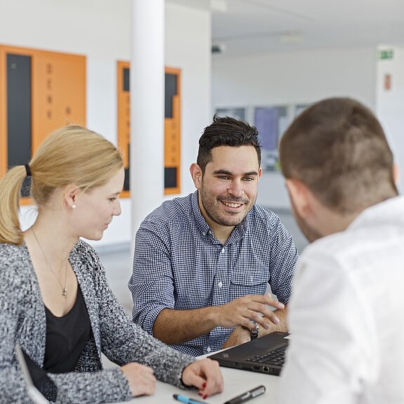 Unterhaltung von Studierenden mit Laptop.