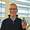 Auf diesem Portraitbild ist Prof. Dr.-Ing. Holger Stahl mit seinem Handy zu sehen.