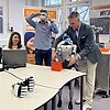 Das Bild zeigt Prof. Andreas Straube mit zwei Studierenden und dem humanoiden Roboter im Innovationslabor der TH Rosenheim.
