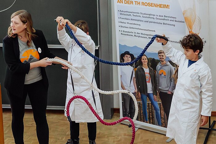 Das Bild zeigt Professorin Nicole Strübbe mit zwei Kindern in der ersten Vorlesung der Kinderuni an der TH Rosenheim.