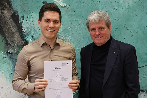 Das Bild zeigt Prof. Kevin Mayer mit Hochschulpräsident Prof. Heinz Köster 